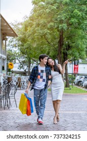 Asian Couple Go Shopping Together Happily During The Daytime.