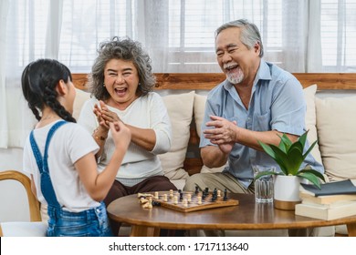 Asian Couple Grandparent With Grandchild Playing The Chess With Happy Feeling Together, Celebrating And Winning, Long Live And Elderly Society,Warm Family And Happiness,social Distancing Concept