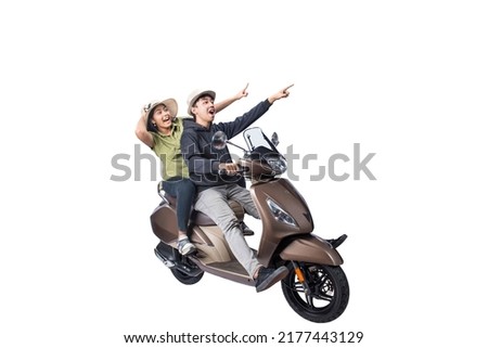 An Asian couple with a hat is sitting on a scooter and pointing something isolated over white background