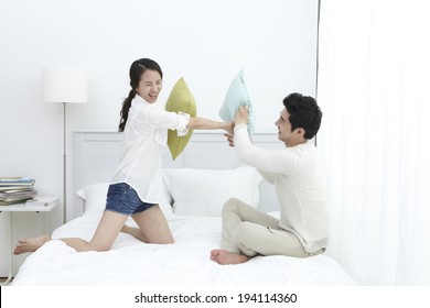 Asian Couple Having A Pillow Fight