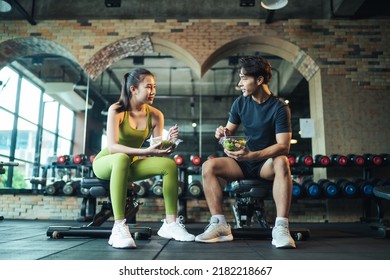 Asian Couple Healthy Eating Salad After Exercise At Fitness Gym. Asian Man And Woman Eating Salad For Health Together.