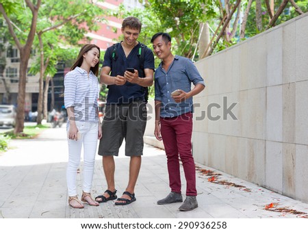 Asian couple help tourist cell smart phone caucasian man mix race friends outdoor city street