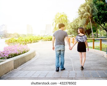 Asian Couple Holding Hands Walking In The Park