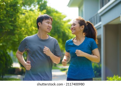 Asian couple are jogging in the neighborhood for daily health and well being, both physical and mental and simple antidote to daily stresses and to socialize safely.