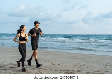 Asian Couple jogging and running outdoors sea sand beach. Sporty people wearing sportswear jogging. Male female athlete running during sunset on the beach. Workout exercise. Healthy and lifestyle. - Powered by Shutterstock