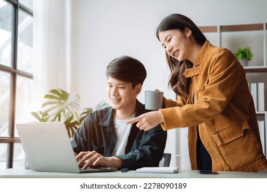 Asian couple looking laptop with happy together in the home. Success of lovers in front of a notebook. Happy couple on social online with a laptop. - Shutterstock ID 2278090189