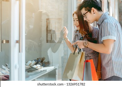 Asian Couple Looking Shoes's Showcase Happily While Shopping.