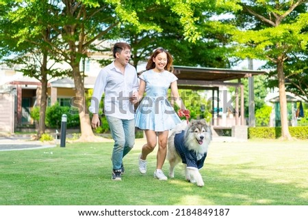 Asian couple love with cute dog in garden