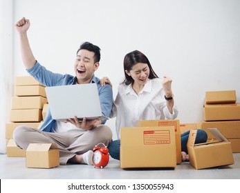 Asian Couple lover checking order and prepare parcel for customers at home,seller online concept.