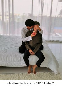 Asian couple lovers on white bed in bedroom holiday. family relationship love together concept.