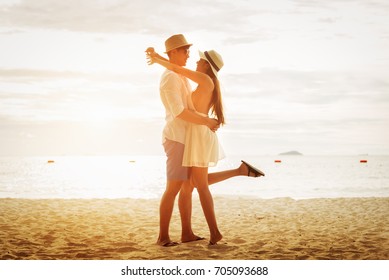 Asian Couple Lying Honeymoon At Sunset Tropical Beach In Thailand