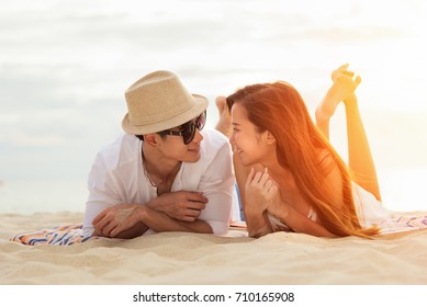 Asian Couple Lying Honeymoon At Sunset Tropical Beach In Thailand