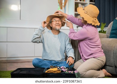 Asian couple old senior marry retired prepare luggage suitcase arranging for travel, Romantic retired couple packing clothes travel bag suitcase together on floor at home interior living room - Powered by Shutterstock