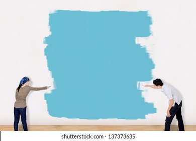 Asian Couple Painting The Wall In Blue