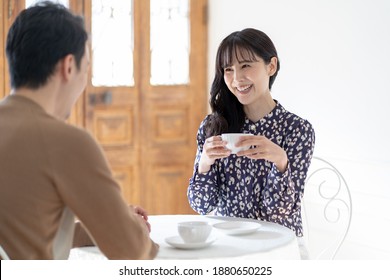 Asian Couple Relaxing In A Coffee Shop