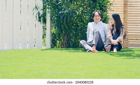 Asian couple relaxing on the lawn.