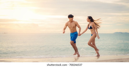 Asian Couple Run Togather On The Beach Between Honeymoon In Resort In Phuket Island, Thailand, Summer, Beach, Holiday, Travel, Family  And Valentine Concept