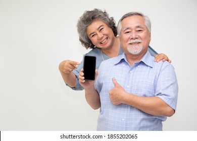 Asian Couple Senior Woman Showing Or Presenting Mobile Phone Application On Hand Isolated On White Background