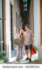 Asian Couple Shopping Happily On Holiday.