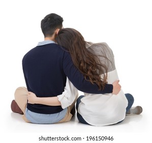 Asian Couple Sit On Ground And Hug Each Other, Rear View On White Background.