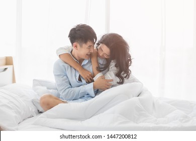 Asian couple sitting on bed together, they hug each other with love, concept for spending time with lover. - Shutterstock ID 1447200812