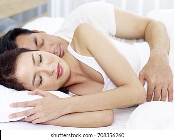 Asian Couple Sleeping In Bed At Home Or Hotel.