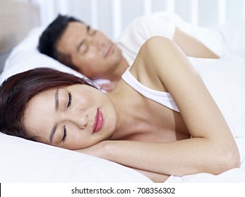 Asian Couple Sleeping In Bed At Home Or Hotel