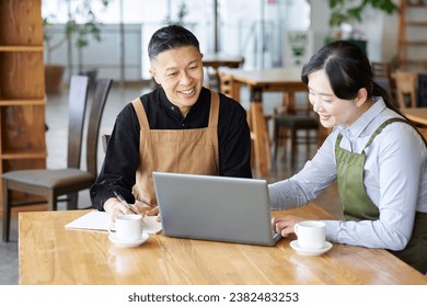 An Asian couple talking about cafe management policy - Powered by Shutterstock