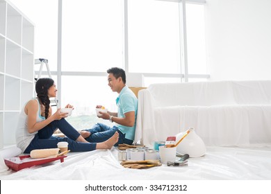 Asian Couple Talking And Eating Instant Noodle After Moving To New House