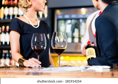 Asian Couple Tasting Red Wine In Wine Shop