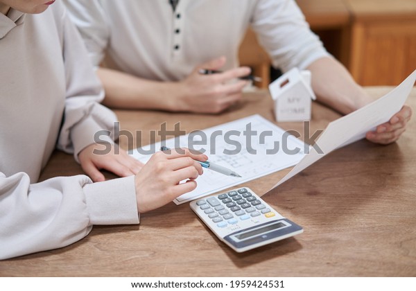 Asian couple thinking\
about buying a home