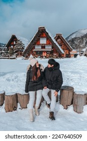 Asian Couple tourist travelling  Shirakawago village with white snow, Japan  Winter Season