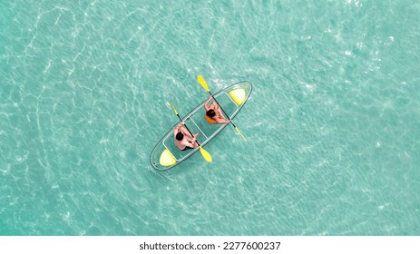 Asian couple travel Pataya by use kayak boat togather on on clean sea water from top view in Thailand