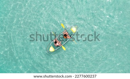 Asian couple travel Pataya by use kayak boat togather on on clean sea water from top view in Thailand