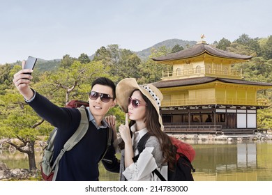 Asian couple travel and selfie in The Golden Pavilion ,Kyoto, Japan.