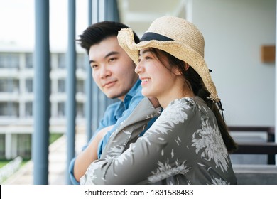 Asian Couple Traveler Standing On Hotel Balcony Looking At The View.