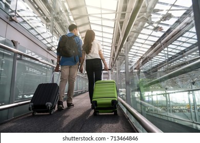 Asian Couple Traveler With Suitcases At The Airport. Lover Travel And Transportation With Technology Concept.