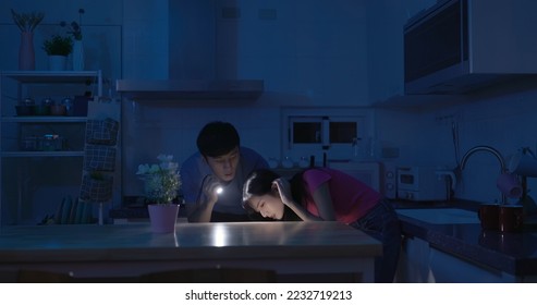 asian couple using flashlight to illuminate are looking for something after power outage in kitchen at home - Shutterstock ID 2232719213