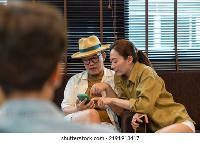 Asian Couple Using Mobile Phone Booking Hotel And Travel Planning Together At Airport Private Lounge In Airport Terminal. Airline Service Business, Airplane Transportation And Holiday Vacation Concept