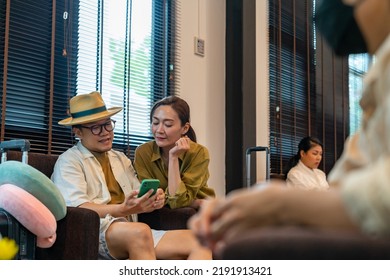 Asian Couple Using Mobile Phone Booking Hotel And Travel Planning Together At Airport Private Lounge In Airport Terminal. Airline Service Business, Airplane Transportation And Holiday Vacation Concept