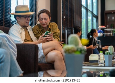 Asian Couple Using Mobile Phone Booking Hotel And Travel Planning Together At Airport Private Lounge In Airport Terminal. Airline Service Business, Airplane Transportation And Holiday Vacation Concept