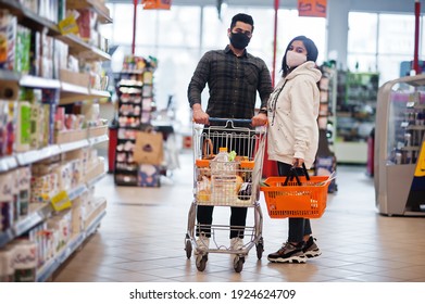 Asian Couple Wear In Protective Face Mask Shopping Together In Supermarket During Pandemic.