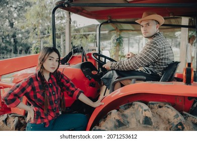 Asian Couple Working With Tractor At Cow Farm