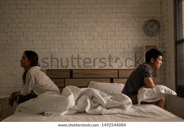 Asian couples quarrel sit in bed ,they\
argue not to talk to each other. They are unhappy \
