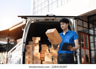 Asian courier with parcel and delivery logistic concept. Delivery man checking address order from cardboard