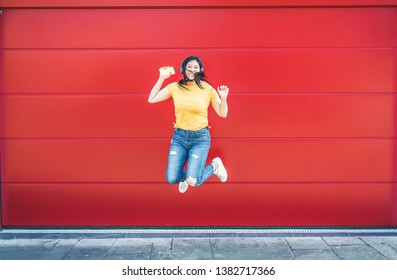 Asian Crazy Girl Jumping And Listening Music Outdoor - Happy Chinese Woman Celebrating And Dancing Outside - Fun, Millennial Generation And Technology Trends Concept - Focus On Body