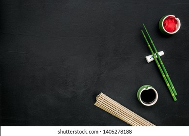 Asian Cuisine Set With Bamboo Sticks, Soy Sauce And Ginger For Sushi And Maki On Black Background Top View Mock Up