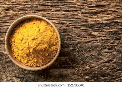 Asian Curry Powder Made From A Blend Of Spices With A Masala Or Turmeric Base In A Small Bowl On A Grunge Textured Wooden Surface, Overhead View With Copyspace