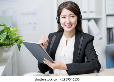 asian customer service representative work and smile at you in the office - Shutterstock ID 1939546135
