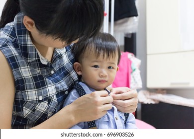 Asian Cute Baby Is Dressing Up With Support Help By Mother In Room.